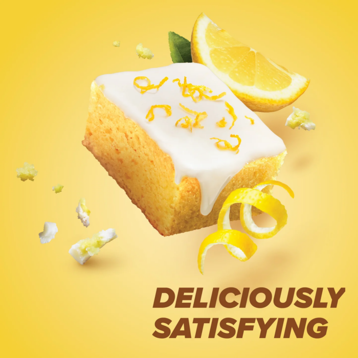 Pure Protein Lemon Cake protein bar styled with lemon glaze drizzle and pretzel pieces on yellow background