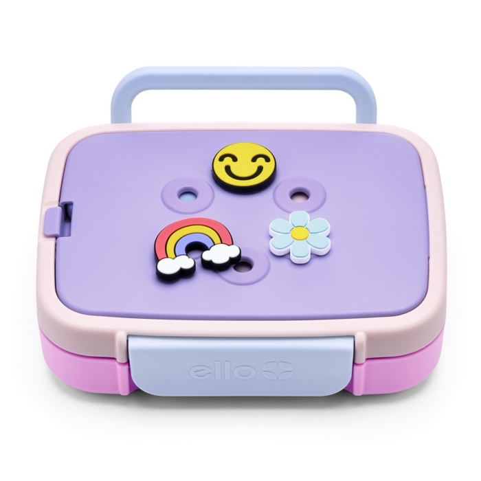 Purple and pink Ello bento lunch box with blue handle and smiley, rainbow, and flower charms attached to the lid on white background
