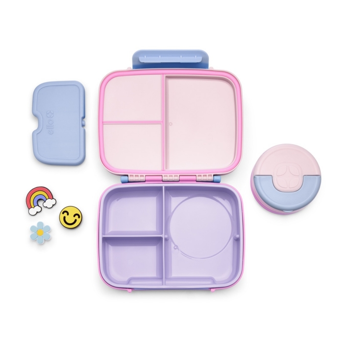 Empty pink and purple Ello bento lunch box with blue lid, round snack container, and rainbow, smiley, and flower charms on white background