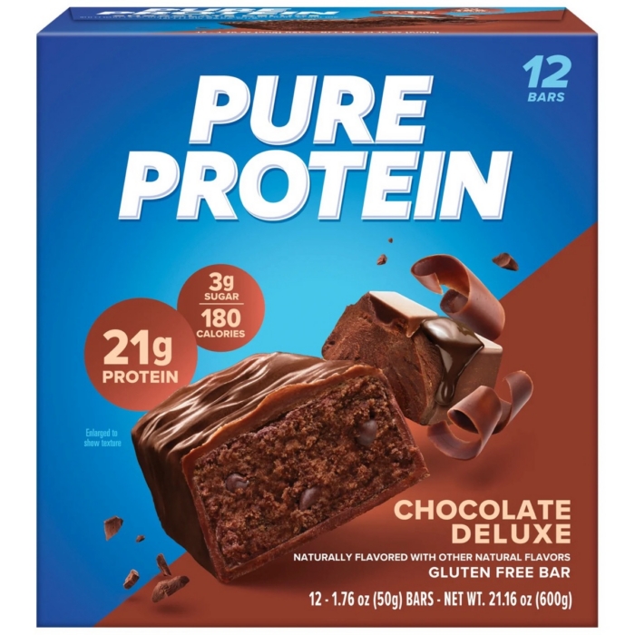 Pure Protein Chocolate Deluxe protein bar box with chocolate bar and drizzle on brown background
