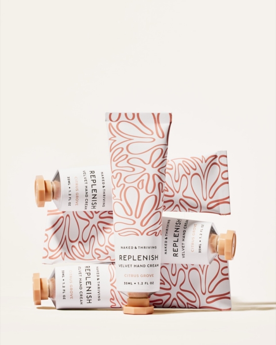 Naked & Thriving skincare collection in pink floral packaging on warm peach background