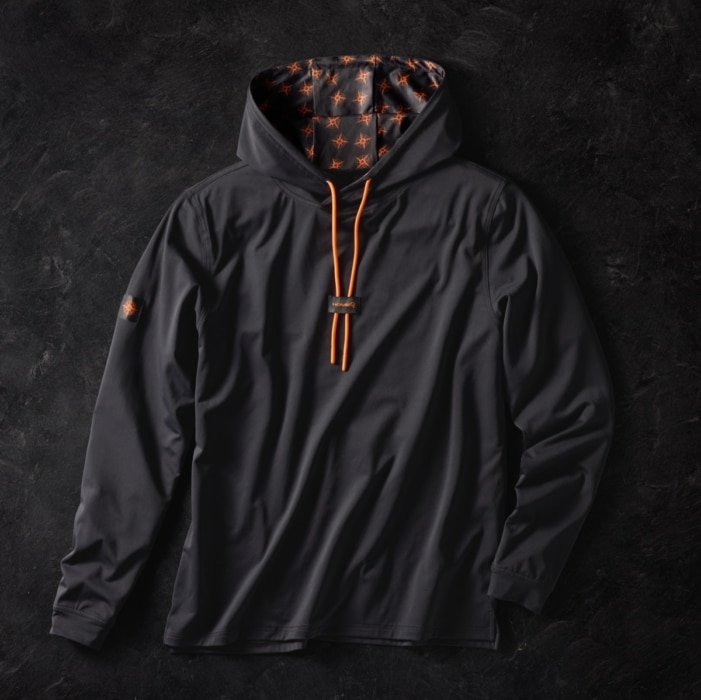Charcoal gray hooded long sleeve shirt with orange drawstrings and star-patterned hood lining, laid flat on dark stone background
