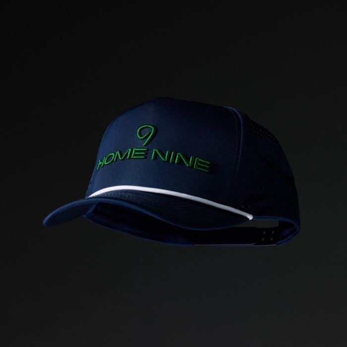 Navy blue performance trucker hat with Home Nine embroidered in green on the front panel and white rope brim trim