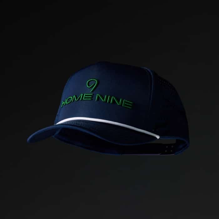 Navy blue performance trucker hat with Home Nine embroidered in green on the front panel and white rope brim trim