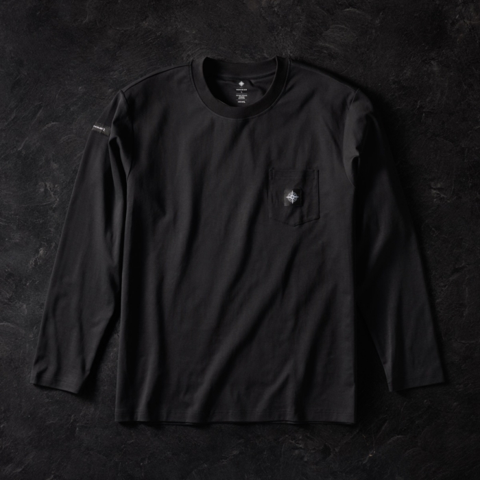Black long sleeve pocket t-shirt with embroidered compass logo on chest pocket and sleeve tag, laid flat on dark stone background