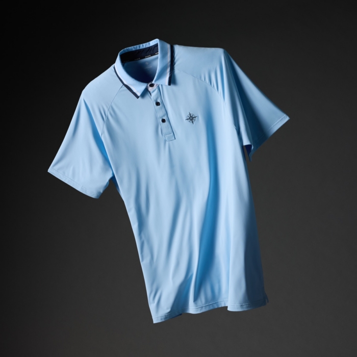 Light blue golf polo shirt with navy and white striped collar and embroidered compass logo on a dark background