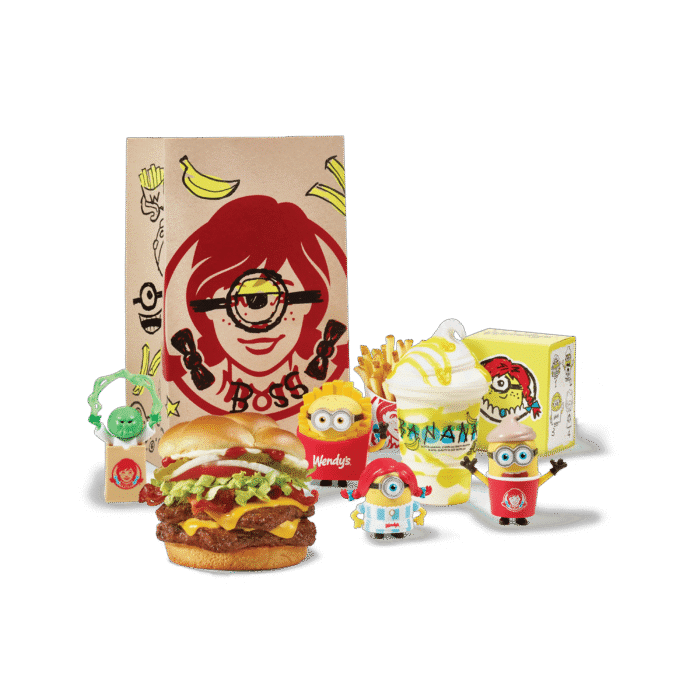 Wendy's Minions and Monsters meal spread featuring a burger, fries, banana Frosty, and four collectible toy figures beside a branded bag