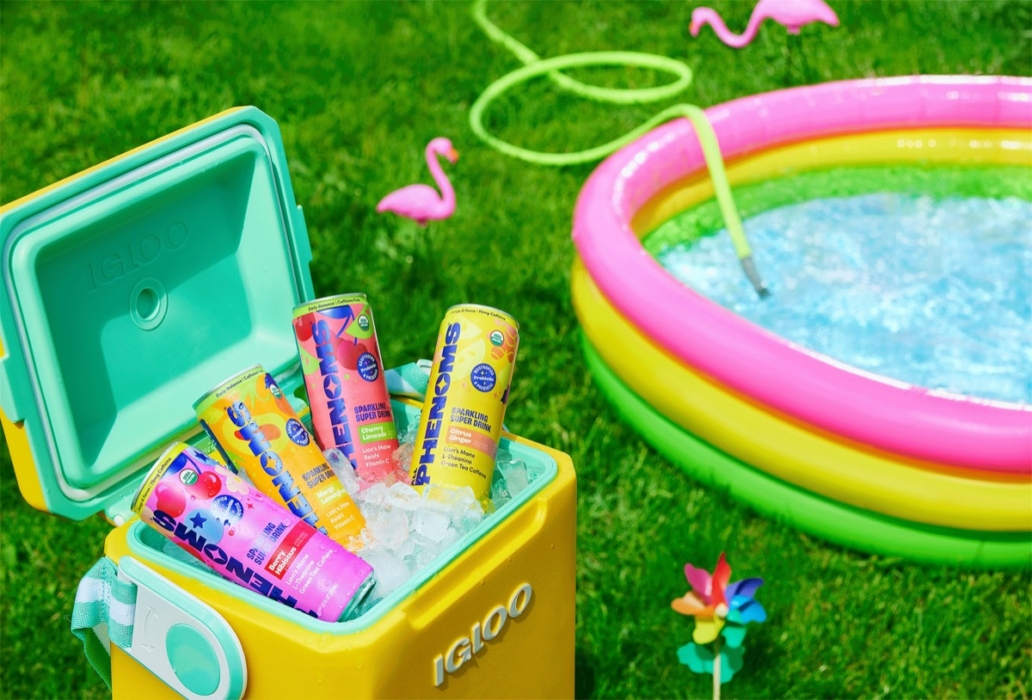 Yellow Igloo cooler packed with ice and colorful assorted freezer pops next to an inflatable rainbow kiddie pool with flamingo yard décor